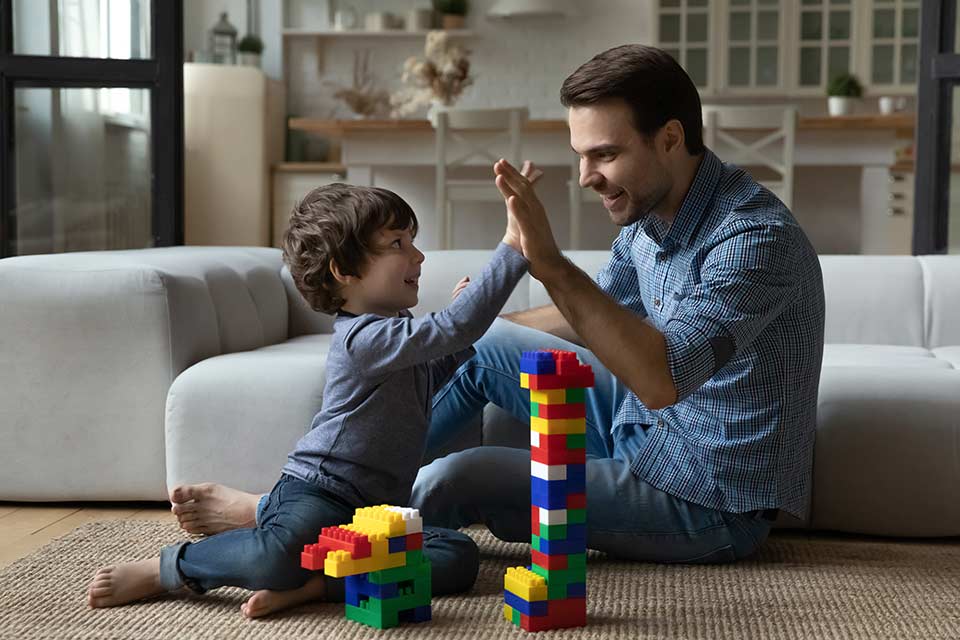 father and son sitting on floor playing